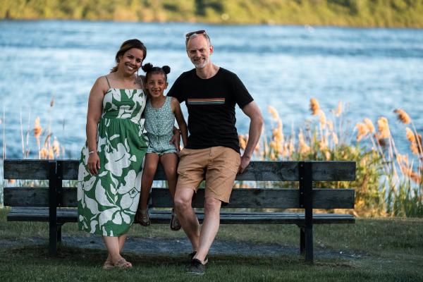 Family of 3 sitting in Lamoureux Park, Cornwall