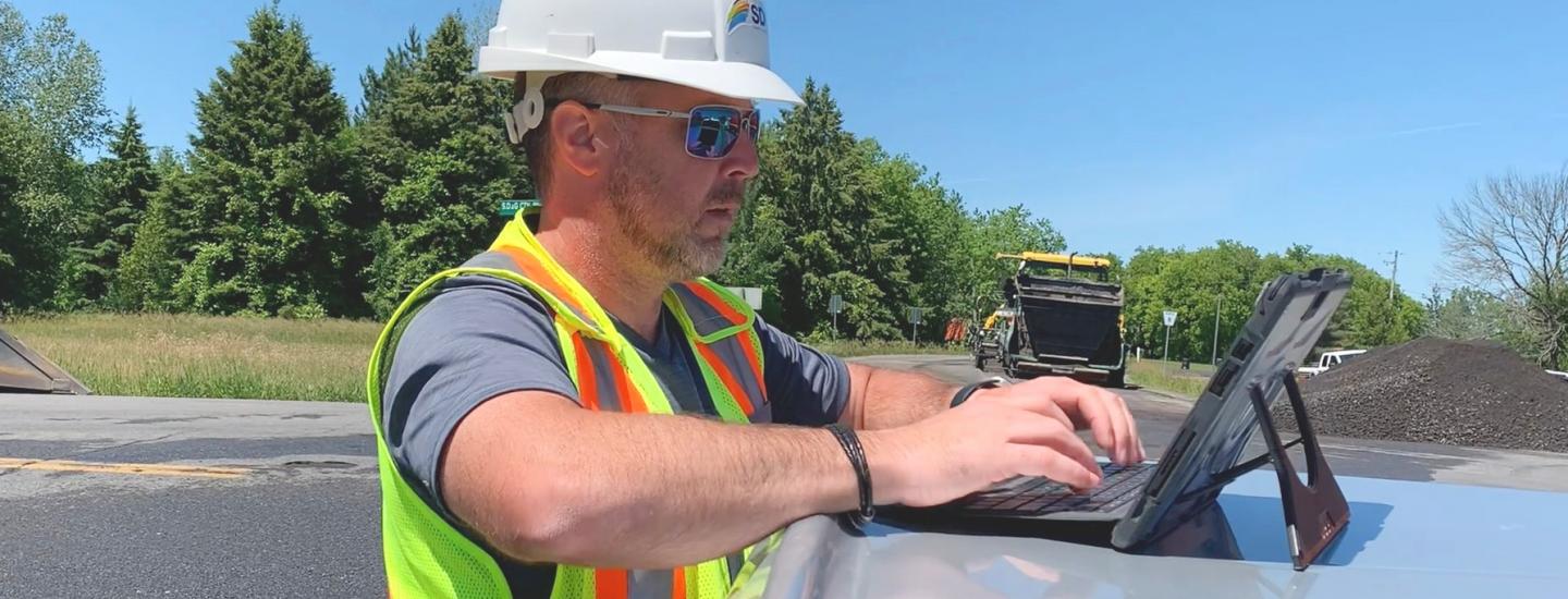 Dana Grant at his laptop on the job site