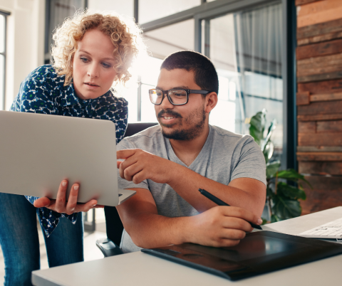 A couple examine materials on a laptop.