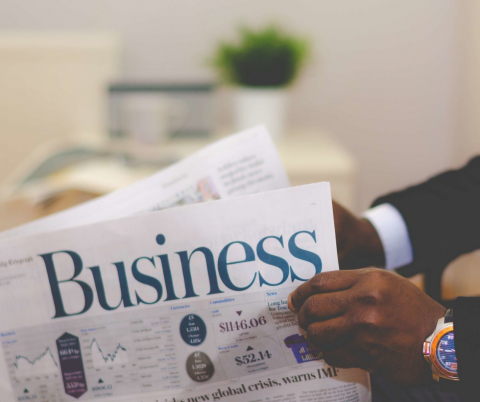 A man reads the business section of a newspaper.